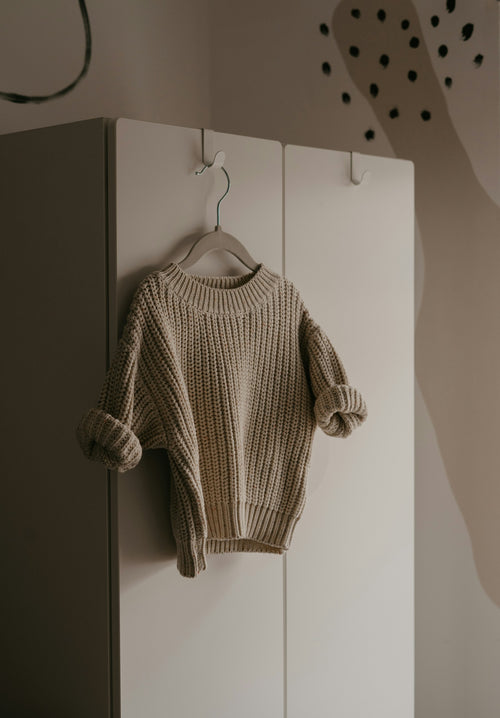 Knitted sweater hanging on a hook